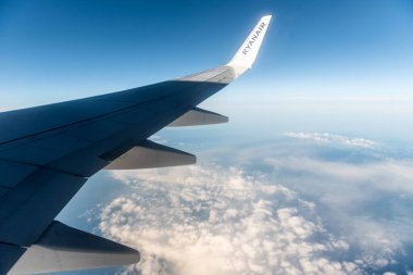Stockholm, İsveç - 19 Temmuz 2024: Bulutlu mavi gökyüzünde uçan Ryanair uçağı. Ryanair logosuna sahip uçak kanadı.