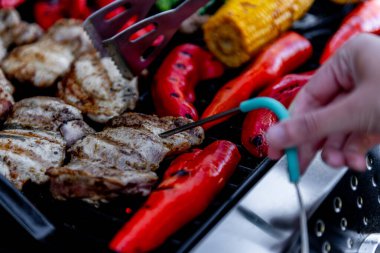 Lezzetli ızgara tavuk eti, sebzeli kuşkonmaz, paprika ve mısır koçanı ızgarada duman ve alevle birlikte..