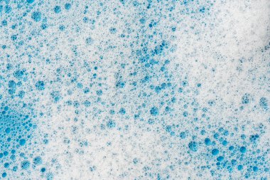 Geçmişi ve düzeni. Kabarcıklı beyaz sabun köpüğü, mavi fayans kaplamalı doku. Döşeme üzerinde deterjan köpüğü. Duş jeli, saç şampuanı köpük lekesi dokusu. Güzellik, temizlik ve çamaşır.