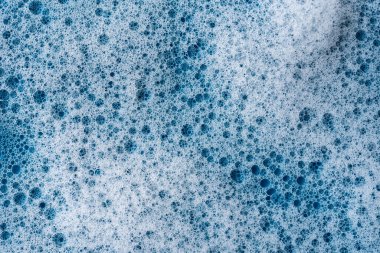 Geçmişi ve düzeni. Kabarcıklı beyaz sabun köpüğü, mavi fayans kaplamalı doku. Döşeme üzerinde deterjan köpüğü. Duş jeli, saç şampuanı köpük lekesi dokusu. Güzellik, temizlik ve çamaşır.