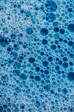 Geçmişi ve düzeni. Kabarcıklı beyaz sabun köpüğü, mavi fayans kaplamalı doku. Döşeme üzerinde deterjan köpüğü. Duş jeli, saç şampuanı köpük lekesi dokusu. Güzellik, temizlik ve çamaşır.