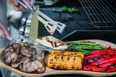 Izgara tavuk, mısır koçanı, paprika, kuşkonmaz ve ahşap kasede halloumi peyniri..