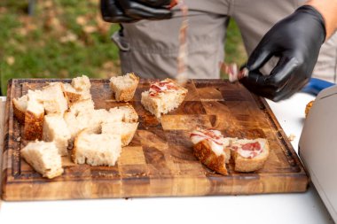 Ekmek ve jambonu ahşap kesim tahtasıyla tatmak için kesiyorum.