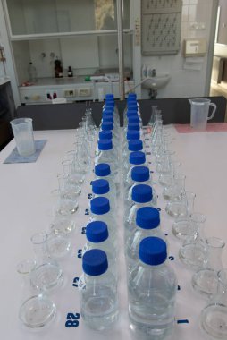 Beyaz masada mavi polipropilen kapaklı laboratuvar şişeleri. Laboratuvar ekipmanları