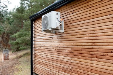 Odunsu ahşap bir ev ve yanında klima var.