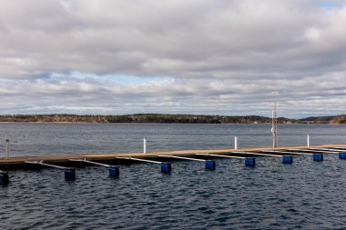 Turist için boş marina ve tekne sezonu başlıyor. Bağlanmanın ilkbahar manzarası. Göl kenarındaki serbest rıhtım manzarası. Güneşli bulutlu bir gün.