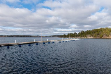 Turist için boş marina ve tekne sezonu başlıyor. Bağlanmanın ilkbahar manzarası. Göl kenarındaki serbest rıhtım manzarası. Güneşli bulutlu bir gün.