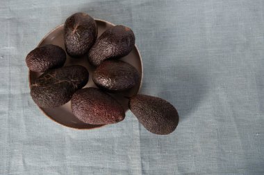 Tekstil arka planında Hass avokadosu. Üst Manzara. Düz çizgi