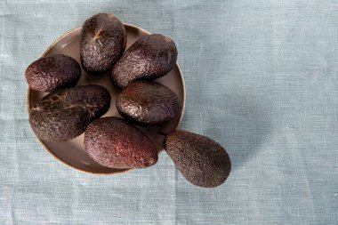 Tekstil arka planında Hass avokadosu. Üst Manzara. Düz çizgi