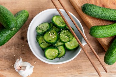 Sunomono, Japon salatalığı. Soya soslu dilimlenmiş salatalık, pirinç sirkesi, susam yağı, ahşap masadaki beyaz klozette şeker ve dereotu..