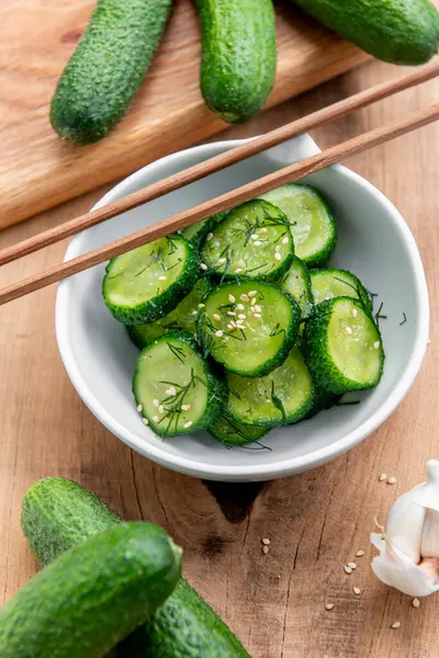 Sunomono, Japon salatalığı. Soya soslu dilimlenmiş salatalık, pirinç sirkesi, susam yağı, ahşap masadaki beyaz klozette şeker ve dereotu..