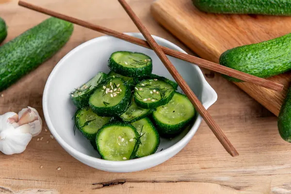 Sunomono, Japon salatalığı. Soya soslu dilimlenmiş salatalık, pirinç sirkesi, susam yağı, ahşap masadaki beyaz klozette şeker ve dereotu..