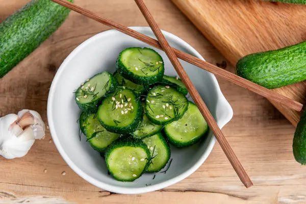 Sunomono, Japon salatalığı. Soya soslu dilimlenmiş salatalık, pirinç sirkesi, susam yağı, ahşap masadaki beyaz klozette şeker ve dereotu..