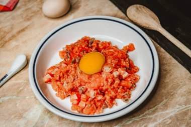 Taze çiğ somon filetosu, somon köftesi veya balık köftesi yapmak için mutfak bıçağıyla doğranır..