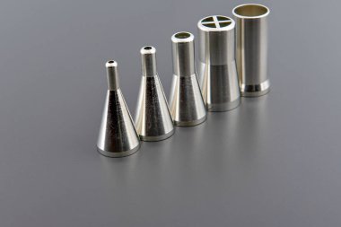 Elektronik imalat için otomatik lehimleme makinelerinde kullanılan, beyaz arka planda, paslanmaz çelik lehim başlıklarını dağıtan yakın plan..