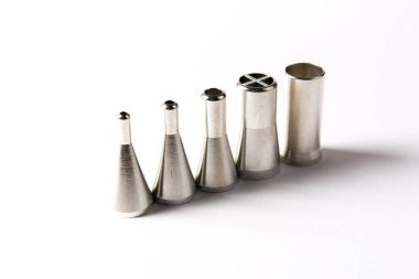 Elektronik imalat için otomatik lehimleme makinelerinde kullanılan, beyaz arka planda, paslanmaz çelik lehim başlıklarını dağıtan yakın plan..