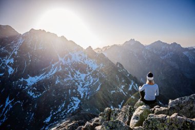 Güzel sarışın kadın Slovak Tatralarında zirveye ulaşmayı seviyor ve Gerlach dağına bakıyor. Mala Wysoka tepesi gün batımında Tatra Dağları 'nda. Yüksek Tatras, Slovakya