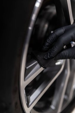 Araba temizleme stüdyosu çalışanı arabanın kenarına seramik kaplama uyguluyor.