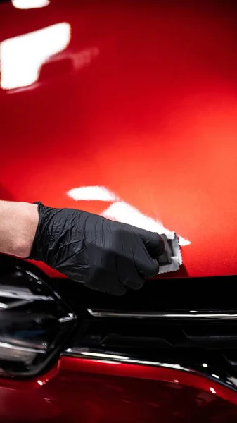 車の洗浄や詳細なスタジオの従業員は 赤い車の塗装にセラミックコーティングを適用します — ストック写真
