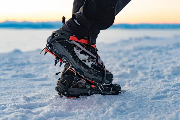 Mountain Boot with crampons on while hiking in the mountains in winter. Mountain winter equipment