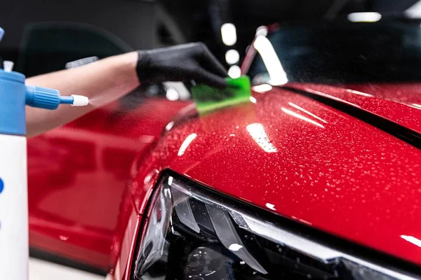 无色保护膜在汽车详细工作室或洗车中的应用 漂亮的红色汽车油漆 图库图片