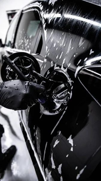 Работник Автомастерской Автомойки Очищает Заправочную Зону Черного Автомобиля Специальной Щеткой — стоковое фото