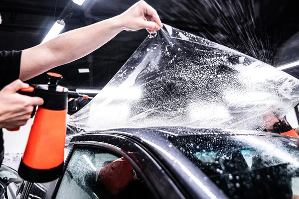 stock image Application of self-healing PPF film on the car roof in a car detailing studio