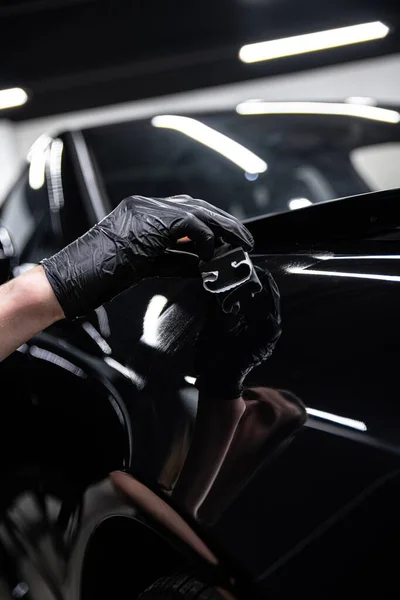 Autowerkstattmitarbeiter Trägt Keramikbeschichtung Auf Den Lack Eines Schwarzen Autos Auf Stockbild