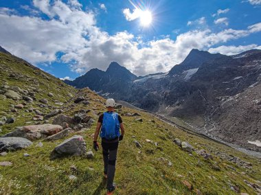 Beyaz kasklı bir adam Avusturya 'daki Alp patikalarında yürüyüş yapıyor. O mavi bir yürüyüş sırt çantası taşıyor. Avusturya 'nın en yüksek dağlarından biri olan Schrankogel' e gidiyor..