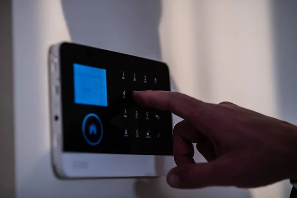 Evdeki Duvardaki Alarm Sistemi Tuş Takımını Kullanarak Adam Şifreyi Alarma Stok Fotoğraf
