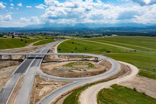 stock image Drone shot of the highway construction from Krakow to Zakopane in the summer. The road will lead into the Polish Tatra Mountains.