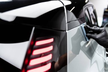 Araba yıkama ya da stüdyo çalışanı gelişmiş koruma ve geliştirilmiş parlaklık için gri boya üzerine seramik ya da grafen kaplama uygular