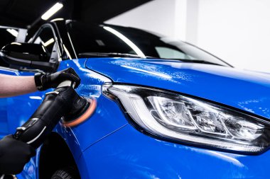 Parlak mavi bir arabanın profesyonel cilalanması kıvrımsız mükemmelliği ve göz kamaştırıcı bir sergi bitmesini garanti eder.