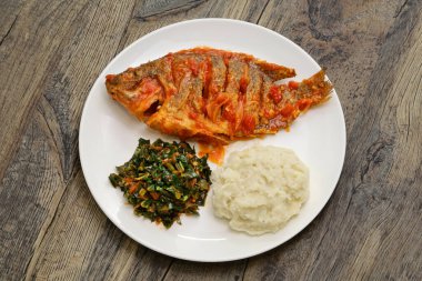 Tilapia yahnisi, ugali (beyaz mısır unu püresi) ve Sukuma Viki (lahana güveci), Kenya yemeği