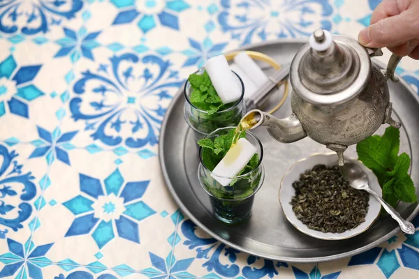 traditional Moroccan mint and sugar tea with a silver teapot