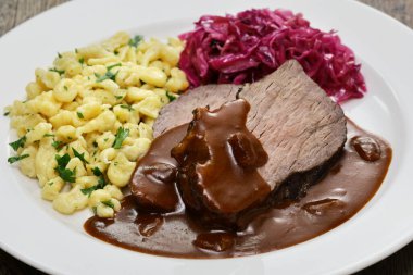 Sauerbraten (Alman ulusal yemeği, terbiye edilmiş dana eti) Rotkohl (kırmızı lahana), Spaetzle (küçük yumurtalı makarna))