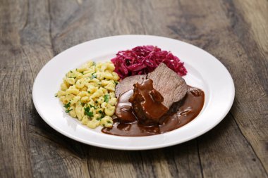 Sauerbraten (Alman ulusal yemeği, terbiye edilmiş dana eti) Rotkohl (kırmızı lahana), Spaetzle (küçük yumurtalı makarna))