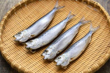 Iwashi marubosi (yarı kurutulmuş Japon sardalyaları) bir bambu tepsisinin üzerinde izole halde..