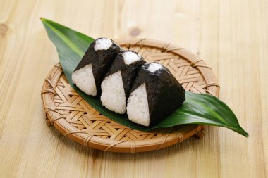 Ev yapımı onigiri (pirinç topları), geleneksel Japon yemekleri. Dolgusu somon gevreği, umeboshi (erik turşusu) ve mentaiko (baharatlı morina yumurtası).).
