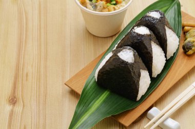 homemade onigiri (rice balls), traditional Japanese food.The filling is salmon flakes, umeboshi(pickled plums), and mentaiko(spicy cod roe).  copy space. clipart