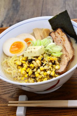 Izgara mısır, tereyağı, kaynamış yumurta, domuz rostosu, bambu filizleri ve Norveç yosunuyla kaplı Japon miso eriştesi..