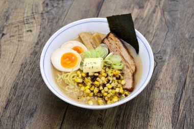 Izgara mısır, tereyağı, kaynamış yumurta, domuz rostosu, bambu filizleri ve Norveç yosunuyla kaplı Japon miso eriştesi..