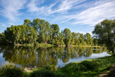 Loire nehri Tours mavi gökyüzünde yeşil ağaç yansımalarıyla 