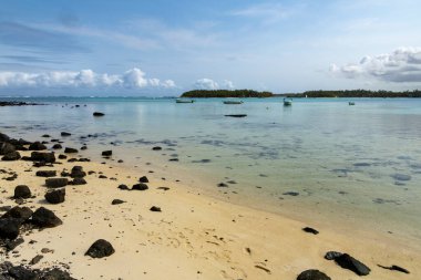 Sandy beach on sunny day with blue skies and ligth clouds Blue Bay Mauritius clipart