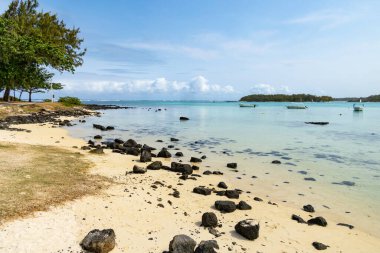 Rocky beach near coral reef  on sunny day with blue skies and light clouds Cap maheureux Mauritius clipart