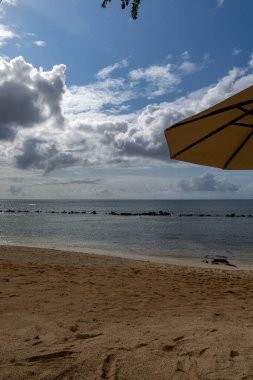 Kumsalda güneşli bir günde mavi gökyüzü ve ışık bulutu ile Turtle Körfezi plajı Mauritius