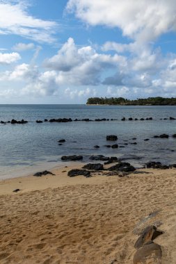 Kumsalda güneşli bir günde mavi gökyüzü ve ışık bulutu ile Turtle Körfezi plajı Mauritius