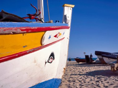 PORTIMAO, PORTUGAL-JANUARY 05: 2019 Plajda açık mavi gökyüzü olan renkli ahşap balıkçı teknesi