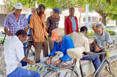 HAVANA, CUBA - 10 AĞUSTOS 2023: Eski Havana caddesinde diğer adamların gözetimi altında dama oynayan adamlar. Checkers, Küba 'nın en popüler oyunlarından biridir.