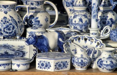 DELFT,HOLLAND- AUGUST 14,2023:Typical Delft blue in a souvenir shop in Delft, The Netherlands. Some of them are antique but the others are not very old clipart